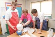 Two autistic boys and a teacher making a cake