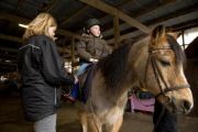 Autistic child riding a horse with instructor