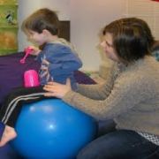 Child with autism sitting on a therapy ball