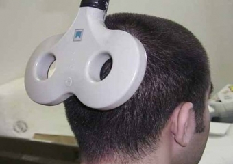Man with transcranial stimulator behind his head